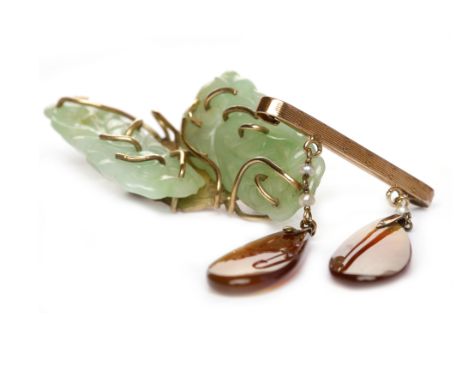 EARLY TWENTIETH CENTURY JADE BROOCHformed by two sections of carved jade on a gold coloured frame, unmarked, 48mm long, 14.3g