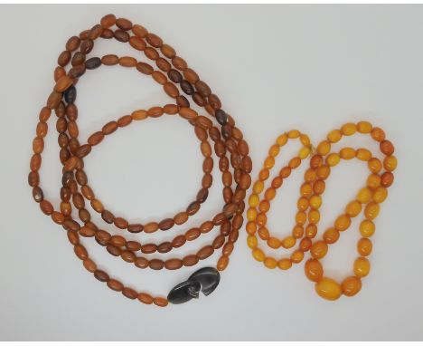 A STRING OF AMBER BEADS AND A STRING OF HORN BEADS the yellow amber beads are 74cm long, the largest bead is 20mm x 16.3mm, s