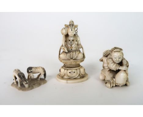 A JAPANESE IVORY NETSUKE carved with a child seated on a turtle man, signed, 4cm high, carving of Kannon seated on a lotus th