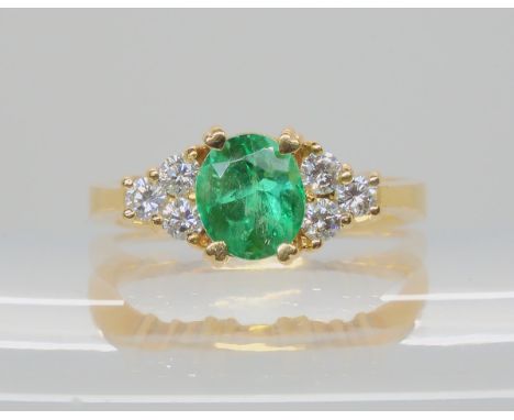 AN EMERALD AND DIAMOND RING mounted in bright yellow metal, emerald approx 7.7mm x 6.7mm x 5.9mm, further set with six diamon