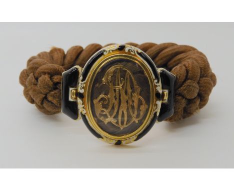 A FRENCH 18CT GOLD HAIR MOURNING BRACELET the black and white enamelled clasp is stamped with the French eagle's head hallmar