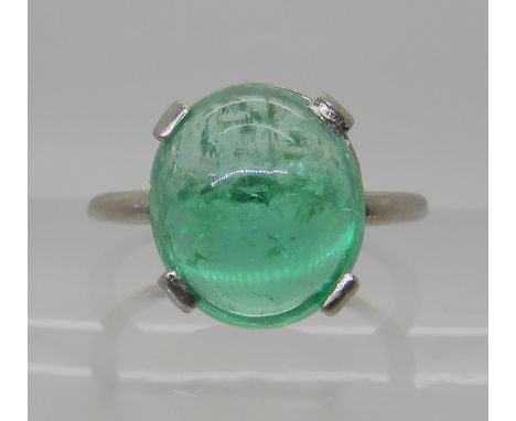 AN ART DECO STYLE EMERALD RING the mount and shank are made in heavy white metal, with a band of black enamel to the bezel, t