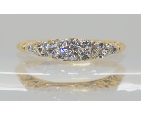 A FIVE STONE DIAMOND RING WITH SCROLLED MOUNT the shank stamped 18, possibly continental, the classic scroll mount is set wit