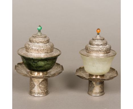 Two Sino-Tibetan carved jade bowls on white metal stands with coversOne bowl spinach green, the other mutton fat, the stands 