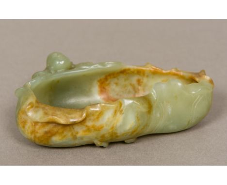 A Chinese carved jade brush washerFormed as a small boy climbing on a side of a leaf.  13.5 cm wide. CONDITION REPORTS: Gener