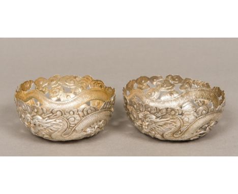 A pair of late 19th/early 20th century Chinese silver bowls Each pierced and worked with a dragon amongst stylised clouds. 11