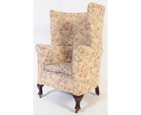 
An Edwardian mahogany wing back - Queen Anne revival chesterfield armchair. Raised on square tapering legs castors having a 