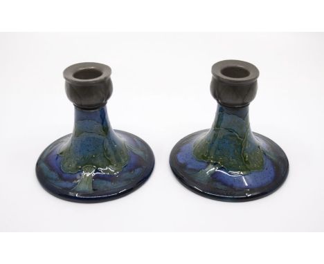 A pair of Moorcroft 'Moonlit Blue' pattern squat candlesticks, circa 1920s, pewter tops, in the Liberty 'Tudric' style, with 