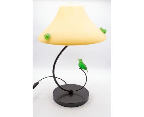 A 20th Century Trait D'union vasoline glass lamp with spiral stem leading to yellow glass shade, with green bird sitting on o