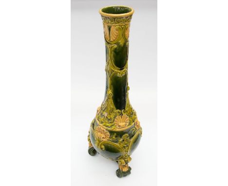 A large glazed art pottery floor vase with three scrolled feet to base, a green background glaze with layered yellow shell an