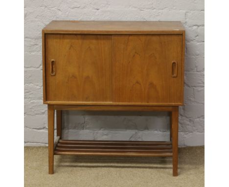 A teak record cabinet with sliding doors and shelf base.