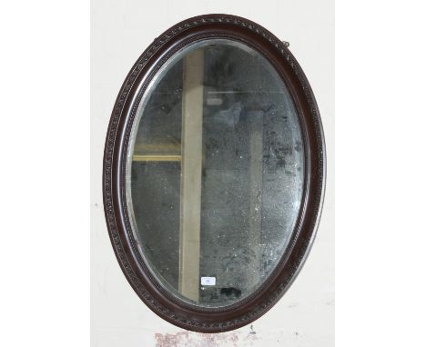 A large oval mahogany framed bevel edge wall mirror.