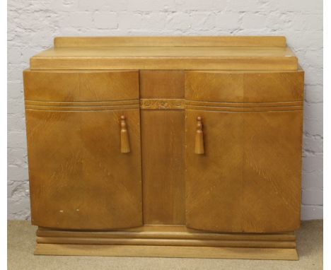 A light oak sideboard with bow front cupboards and fitted interior.