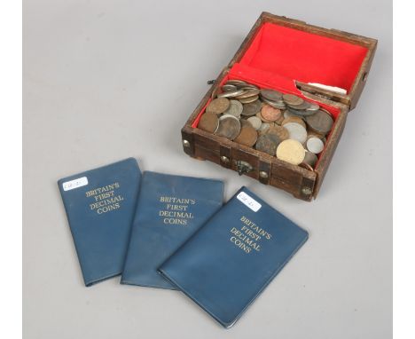 A collection of British and foreign pre-decimal coins in a hardwood case along with three albums of British first decimal coi