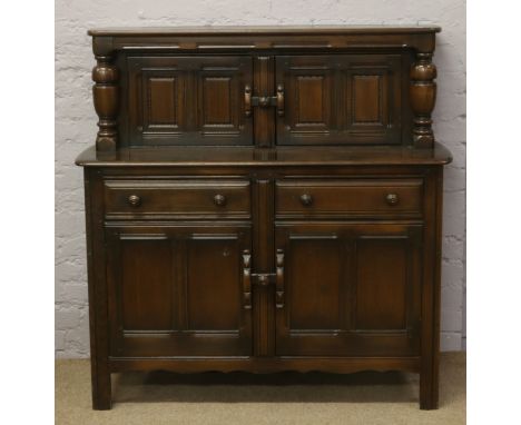 A carved and panelled dark oak Ercol court cupboard.