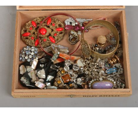 A cigar box of costume jewellery bangles, pendant, cufflinks etc.