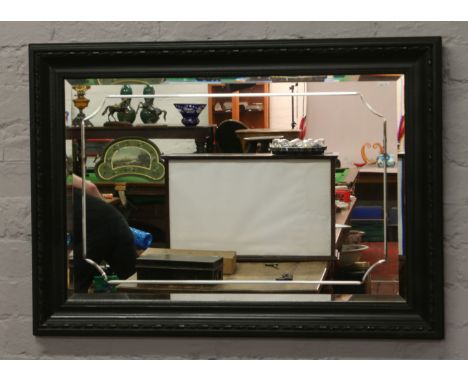 A framed bevel edged wall mirror.