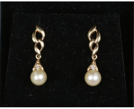 A pair of 14ct gold diamond and cultured pearl drop earrings with 9ct gold butterfly backs.