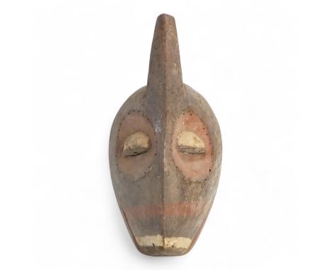 A polychrome painted tribal African mask - with red eye sockets and drilled border, together with a pointed brow, 36cm high.