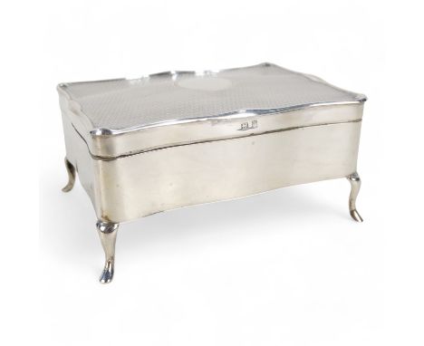 A silver jewellery casket - Birmingham 1912, rectangular with engine turned hinged lid and velvet fitted interior, raised on 