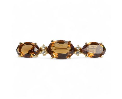 A Christian Dior yellow metal brooch - set oval faceted brown stones and white stones, length 6cm.