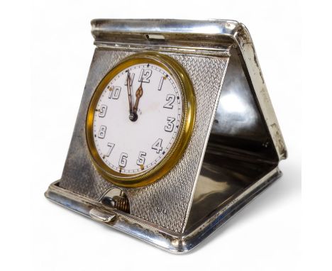A silver cased bedside travelling timepiece - London 1916, with a square engine turned case of bowed form, the white enamel d