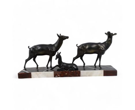 An early 20th century Art Deco bronze group - two deer with resting fawn, raised on a rectangular marble base, 67cm wide.