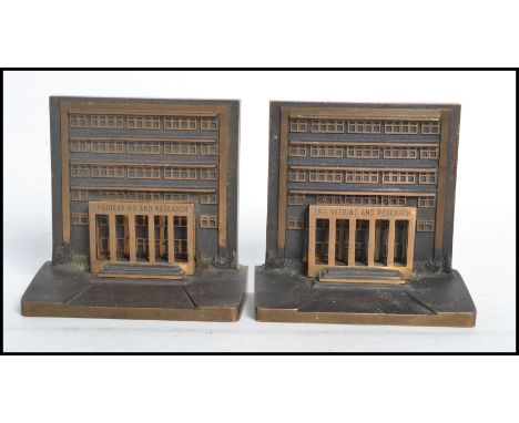A pair of 20th century National Engineering and Research bronze prizes in the form of bookends, one having plaque to back for