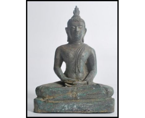 A 19th century Oriental Chinese bronze figurine of a Buddha in the seated lotus position raised on a pedestal base. Measures 