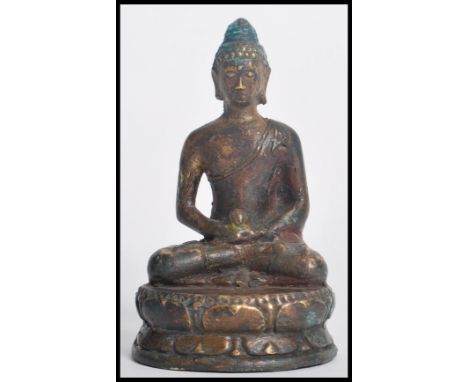 A 19th century Chinese bronze figurine of a Buddha modelled in the lotus position holding a pot raised on a pedestal base. Me