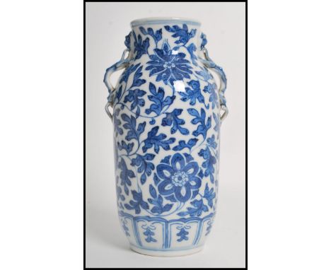 A 19th century blue and white ceramic vase having twin Chinese dragon handles with a hand painted foliage decoration to the b