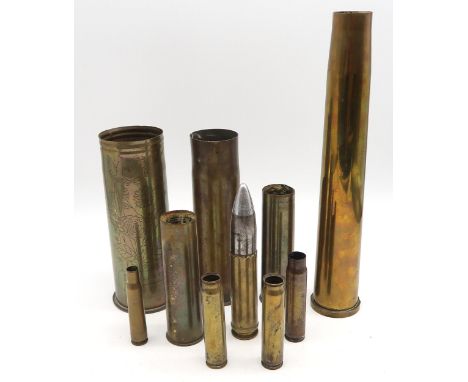 An inert artillery round, together with a selection of brass shell casings, including a WW1 Trench Art example engraved "Ypre
