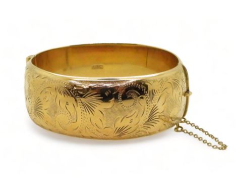 A 9ct gold wide engraved hollow bangle, inner diameter 6cm x 5.5cm, 2.4cm wide, weight 34.4gms Condition Report:Some very min