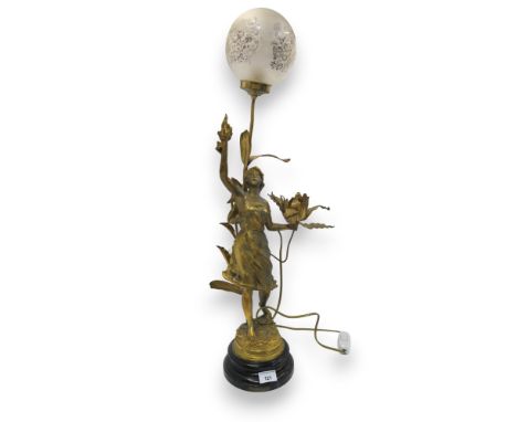 After E Rousseau, a gilded spelter lamp modelled as a maiden holding a flower in one hand and a flaming torch in the other, t