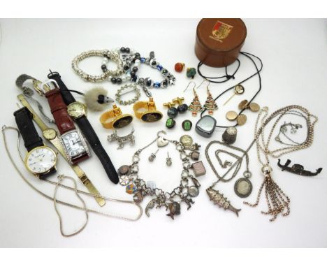 A silver charm bracelet with fifteen silver and white metal charms to include enamel examples, a 'Ten Bob' note etc, a silver