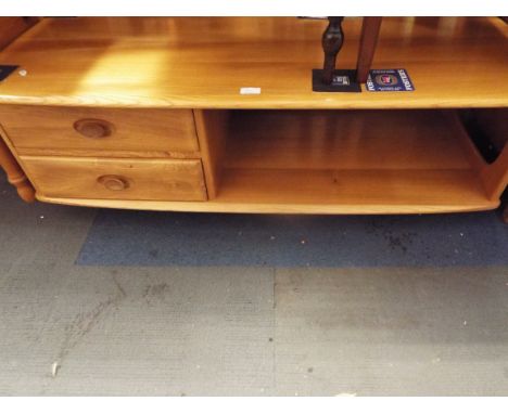 An Ercol light elm coffee table fitted with two short drawers and undertier, raised on castors