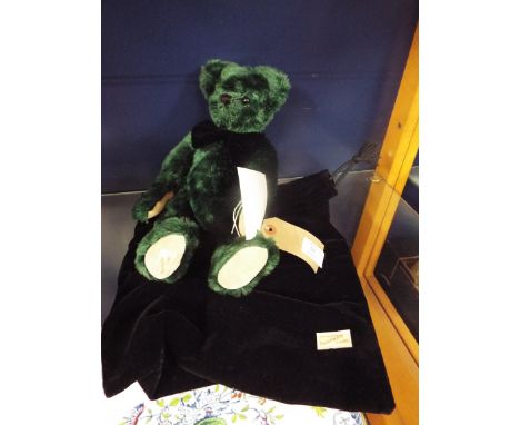 A Deans Rag Book Company limited edition luxury bear range teddy in green mohair with black bow tie and velvet drawer string 