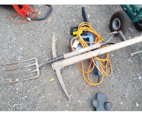 A Challenge Extreme electric chainsaw together with a garden fork and pickaxe