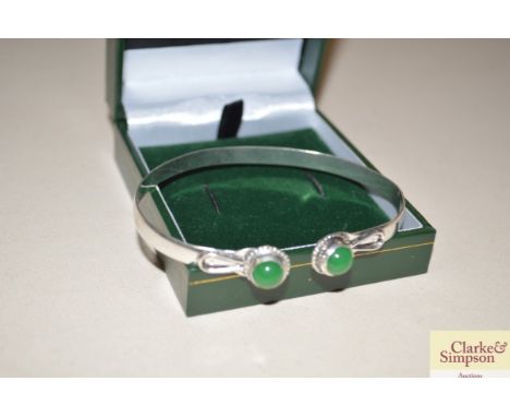 A white metal and green stone bangle