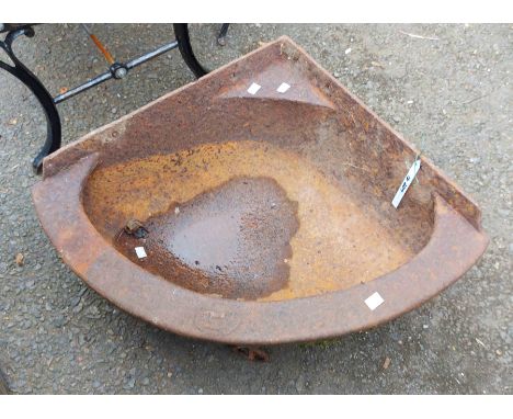 A large cast iron corner feed trough