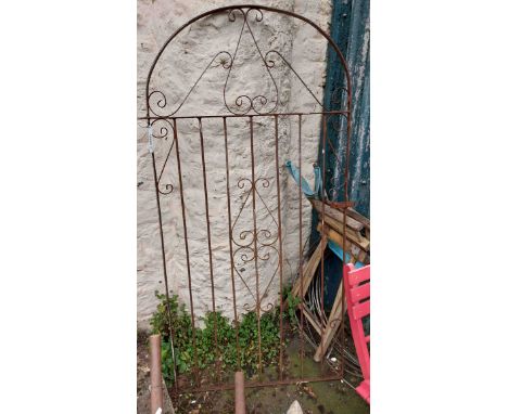 An old wrought iron garden gate of scroll design