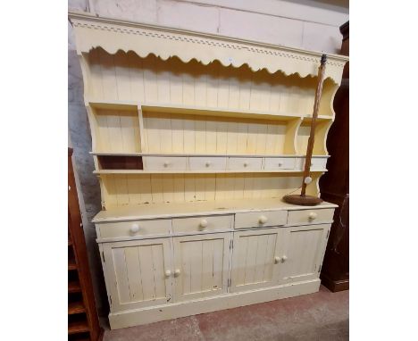 A 1.85m pine two part dresser with cream painted finish, the two shelf open plate rack with six spice drawers over a base wit