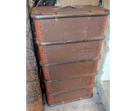 A vintage cane bound travelling trunk with tray fitted interior and leather strap handles
