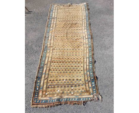 A vintage handmade wool runner with repeat pattern within a triple border on honey brown ground - wear to end and a few holes