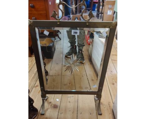 A brass framed fire screen with cut decoration to the inset bevelled mirror panel