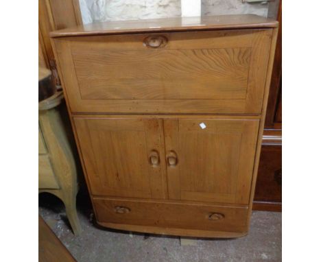 An 82.5cm vintage Ercol 'Windsor' light elm cocktail cabinet with fall-front compartment, pair of cupboard doors and long dra