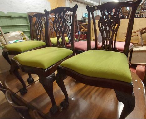 A set of four Chippendale style mahogany framed ribbon back dining chairs with upholstered drop-in seats, set on cabriole fro