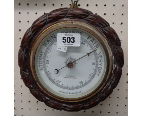 A late Victorian oak rope twist framed aneroid barometer with printed ceramic dial marked for 'Aitcheson, London &amp; Provin
