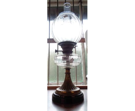 A vintage brass and glass oil lamp set on black base