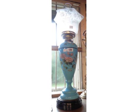 An old blue glass oil lamp with hand painted decoration to base and floral pattern glass shade